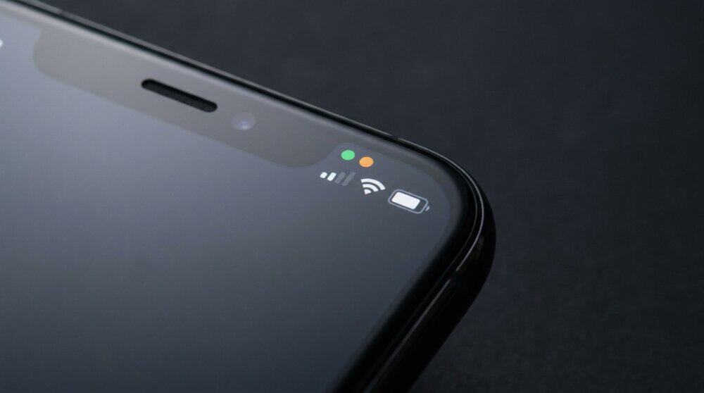 iPhone status bar showing green and orange dot indicators for camera and microphone access