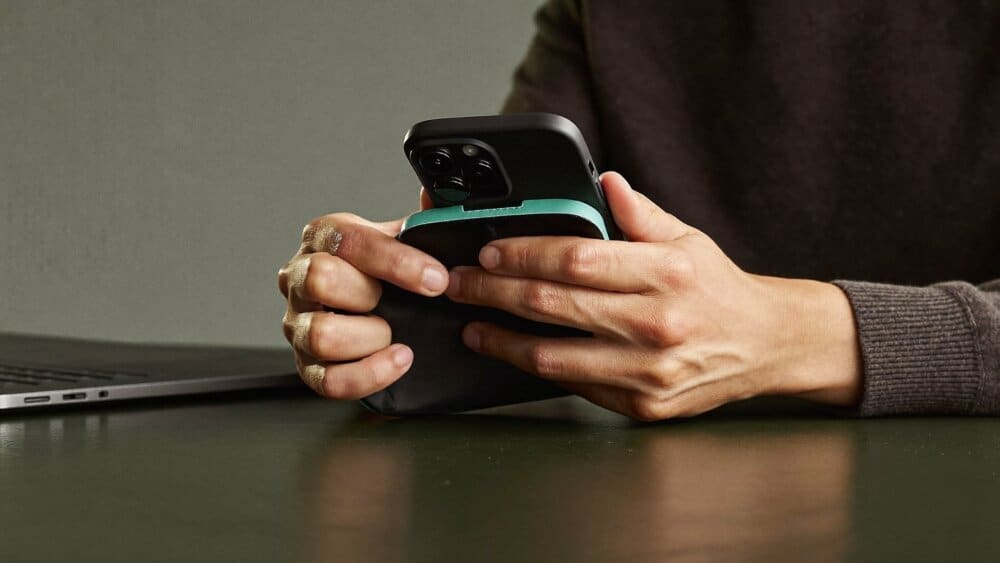 Person securing and resetting their phone at a desk to remove stalkerware