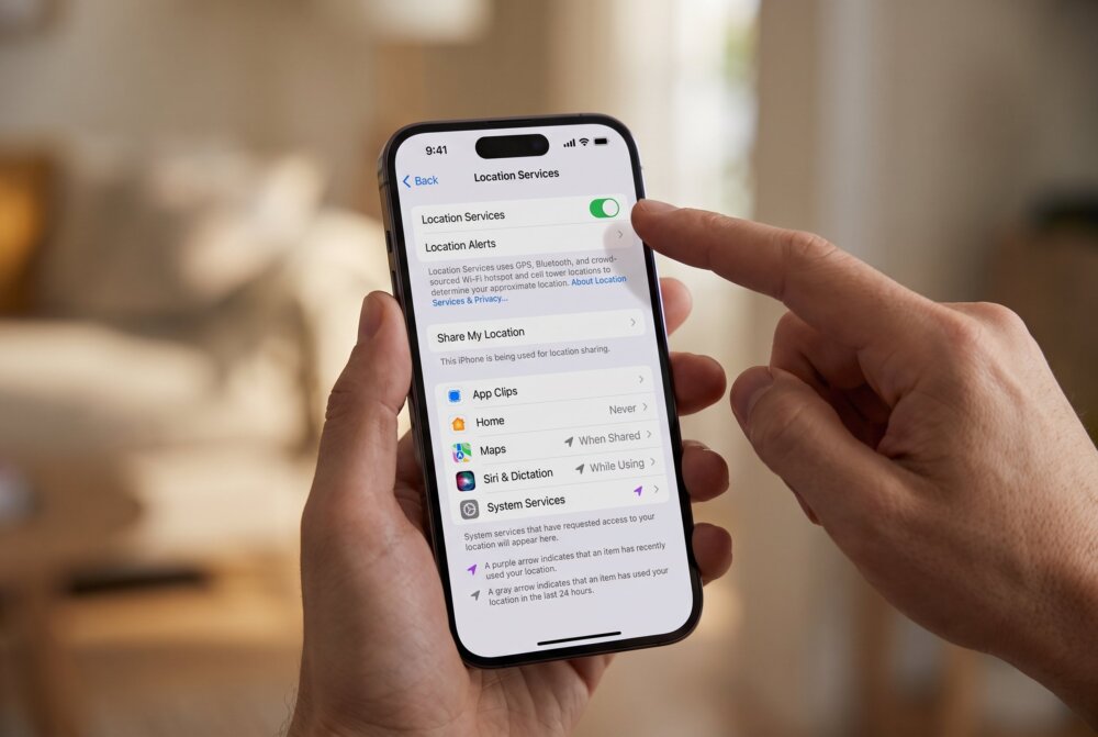 A hand turning off Location Services in the iPhone Settings app to stop location tracking